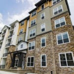 The James Apartments | Exterior view of a modern multi-story apartment building with stone accents and mixed siding, featuring large windows and balconies | Luxury Apartments in Haverhill MA