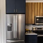 The James Apartments | Close-up of a modern kitchen stove and microwave with custom tile backsplash and decorative accents including a bowl of lemons and a brass bowl on the countertop | Princeton Properties growth and developments