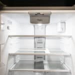 The James Apartments | Interior view of an open stainless steel refrigerator showing clean, empty shelves and door compartments | Luxury Apartments in Haverhill MA