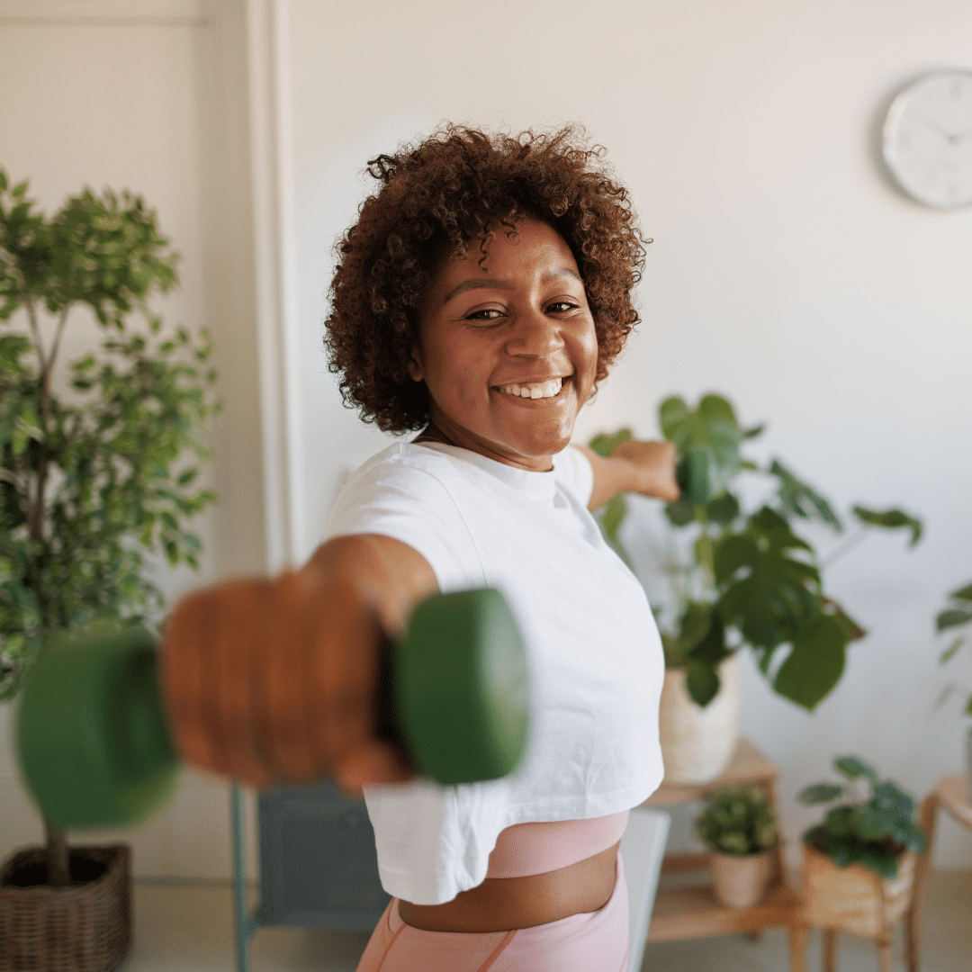 Princeton Properties | Woman with green free weights working out in her apartment surrounded by her house plants | Fitness